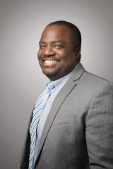 corporate headshots on grey background in grey suit with blue striped tie stylized photography by arielle lewis studios in washington dc