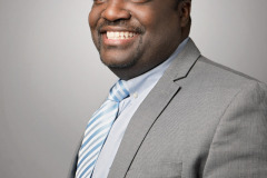 corporate headshots on grey background in grey suit with blue striped tie stylized photography by arielle lewis studios in washington dc