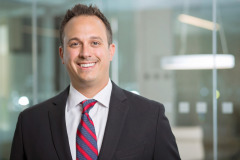 relaxed male doctor in full suit with red and grey striped tie smiling headshot in washington DC