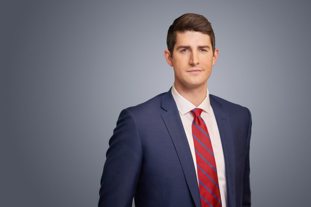 male lobbyist headshots in blue suit with red tie on grey background arielle lewis studios